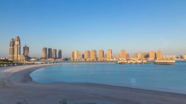 Katara Sahili 'nden gün batımında Doha, Katar' da İnci 'ye doğru bir görüntü. İkamet binaları görünümü