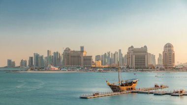 Katara Sahili 'nden Doha, Katar' da gün batımında Batı Körfezi 'ne ve şehir merkezine doğru bir görüntü. Öndeki eski gemi