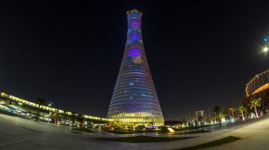 Gece Doha Spor Şehri 'ndeki Aspire Kulesi ya da Torch Hotel zaman tüneli. Doha, Katar, Orta Doğu. Aydınlatılmış gökdelen