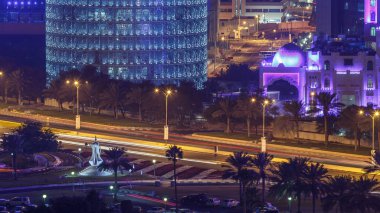 Doha Corniche ve kahve demliği anıtı. Havadan görünüşlü. Arka planda aydınlık gökdelenler ve yolda trafik