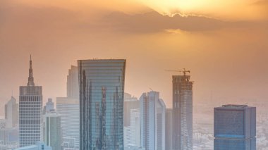Günbatımında gökdelenler başkent Katar 'ın ticaret merkezi Doha' nın ufuk çizgisinde. Sisli havada hava manzarası. Bulutlu turuncu gökyüzü