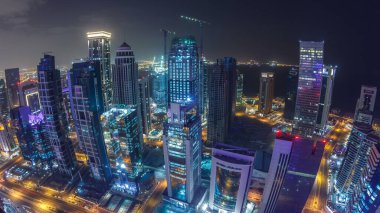 Katar 'ın Doha Zaman Çizelgesi' nde Batı Körfezi bölgesinin ufuk çizgisi. Aydınlatılmış modern gökdelenler geceleri çatıdan gökyüzü manzarası. Yollarda trafik vardı. Fisheye merceği