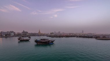 Geleneksel ahşap Dhow balıkçı tekneleriyle Doha Körfezi 'nde gece gündüz geçiş zamanı. Corniche, Doha, Katar ile müzeden görüntü