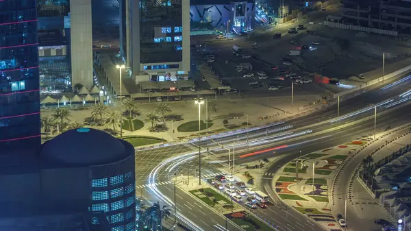 ドーハのタイムラプス カタールの上から西湾地域の道路上の交通 ライトアップされた近代的な高層ビル群と夜の屋上からの空中風景 — ストック写真