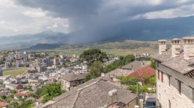 Cirokastra şehrini, Cirokaster 'ın zaman ayarlı çatıları olan tipik tarihi evlere sahip panorama perspektiften gösteriyor. Arnavutluk havadan yağmur bulutları ve duş hareketleriyle vadiye bakıyor