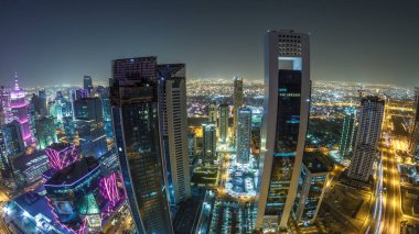 Katar 'ın Doha Zaman Çizelgesi' nde Batı Körfezi bölgesinin ufuk çizgisi. Aydınlatılmış modern gökdelenler geceleri çatıdan gökyüzü manzarası. Yollarda trafik vardı. Fisheye merceği