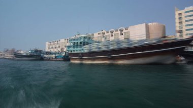 Dubai 'deki Deira Deresi' ndeki Abra gemisinden görüntüler, BAE zaman atlaması. En ucuz nakliye aracı. Rıhtımdaki binalar. Bulanık hareket