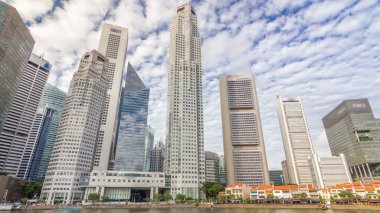 Downtown skyscrapers office buildings of modern megalopolis timelapse hyperlapse. Skyline of Singapore city reflected in water. Reflections in glass surface and clouds on the sky