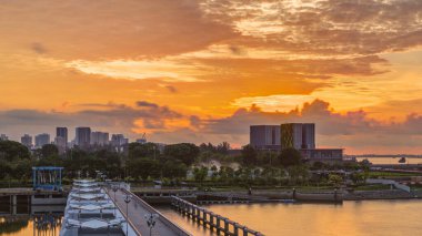 Marina Barrage 'da güzel bir gün doğumu zamanı. Turuncu gökyüzü ve güneş ışınlı bulutlar. Singapur 'un 15. su deposu ve şehrin göbeğindeki ilk su deposudur..