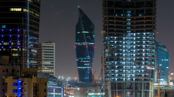 Городской пейзаж Кувейта с ночными небоскребами в центре Кувейта освещается в сумерках, на Ближнем Востоке. Вид с крыши