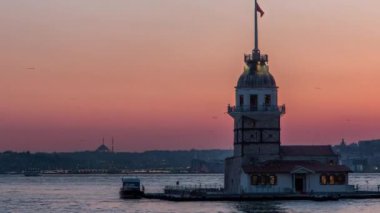 Maidens tower after sunset day to night transition timelapse in istanbul, turkey, kiz kulesi tower. City skyline on background with reflection on Bosforus water