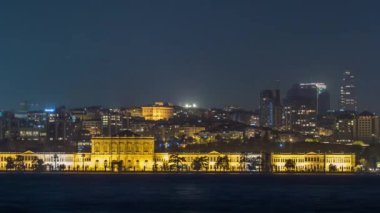 Illuminated Mimar Sinan University night timelapse. View to besiktas district in Istanbul taken from asian part of the city. Reflection on Bosphorus water