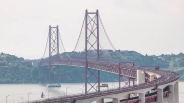 Lizbon 'da koşmak 25 Nisan köprüsünü yukarıdan Tagus Nehri' nin havadan görünüşü üzerinden geçmek demek. Büyük bir kalabalık baştan sona köprüden aşağı ilerliyor. Tren geçiyor.