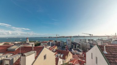 Panorama, Portekiz, Lizbon 'daki Tagus Nehri üzerindeki 25 de Abril Köprüsü ve kırmızı çatıları gösteriyor. Miradouro de Santa Catarina 'dan hava manzarası. Güneşli bir günde klasik bakış açısı