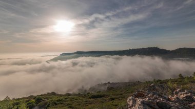 Panorama showing aerial View of Sesimbra Town and Port covered by fog timelapse, Portugal. Top landscape above the clouds and setting sun. Resort in Setubal district clipart