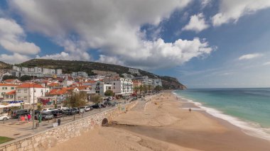 Panorama, Portekiz 'de Sesimbra Kasabası' nın ve deniz kıyısında yürüyüş zamanının hava görüntüsünü gösteriyor. Evleri ve kaleden kumsalları olan bir yer. Setubal ilçesinde tatil köyü