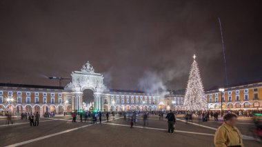 Panorama, Ticaret Meydanı 'nın ışıklandırılmış kemerini ve Lizbon' da Noel zamanında süslenmiş halini gösteriyor. Noel ağacı ve insanların toplandığı bir meydan. Tatil zamanları. Portekiz