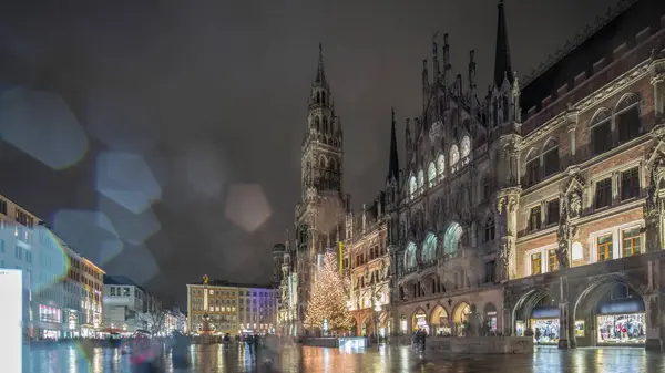 Marienplazt Old Town Square with New Town Hall night timelapse hyperlapse. Neues Rathaus and Town Hall Clock Tower Glockenspiel. Munich skyline, downtown cityscape. Rainy weather. Bavaria, Germany