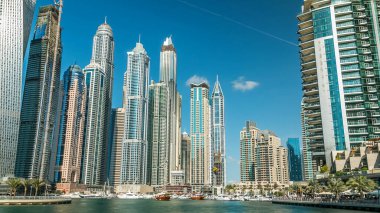 Dubai Marina modern uzun kuleleri, Birleşik Arap Emirlikleri 'ndeki gezinti zamanlarından suya yansıdı. Dubai 'de bir bölge ve tekneli yapay bir kanal. Mavi bulutlu gökyüzü