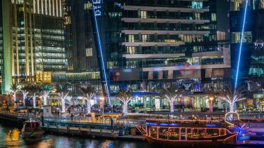 Dubai Marina rıhtımı, yatları ve Dubai 'deki köprüden modern kuleleri olan gece zaman çizelgesi, Birleşik Arap Emirlikleri. Eski turistik tekne.