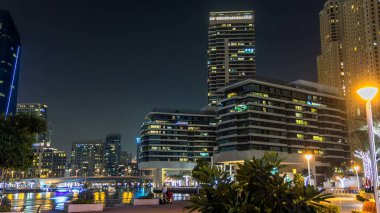 Dubai Marina, yatları ve briç gecesi hiperhızlandırılmış restoranları olan modern kuleleri olan, Birleşik Arap Emirlikleri ile dolanıyor. Gökdelenlerde parlayan pencereler