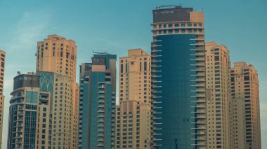 Dubai Marina Modern Kuleleri 'nin sabah manzarası. Dubai' deki yat kulübünden. Gün doğumunda, Birleşik Arap Emirlikleri. Gölgeler hızlı ve korunmasız binalara doğru ilerler. Gökdelenler gökyüzü çizgisi