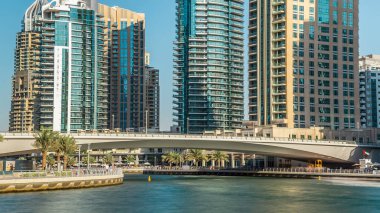 Dubai Marina modern kuleleri ve yüzen yatları ve gezinti güvertesinden botları olan köprü, Birleşik Arap Emirlikleri. Gökdelenlerin en yükseği. Mavi gökyüzü