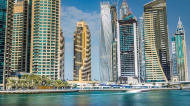 Dubai Marina modern kuleleri yüzen yatları ve gezinti güvertesinden botları olan Birleşik Arap Emirlikleri. Gökdelenlerin en yükseği. Mavi bulutlu gökyüzü