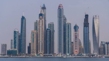 Dubai Marina ufuk çizgisi günden geceye geçiş zamanı panorama Palm Jumeirah, Dubai, BAE 'den görüldüğü gibi. Dubai 'nin bu kısmında 50 kattan fazla gökdelen var.