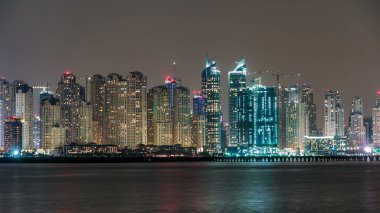Dubai Marina silueti JBR gece zaman çizelgesi ile Dubai, BAE 'deki Palm Island' da görülüyor. Dubai 'nin bu kısmında 50 kattan fazla gökdelen var.