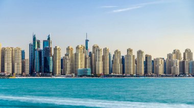 Jumeirah Sahili Residence, gün batımında gökyüzünde Palm Jumeirah 'dan deniz zaman ayarlı olarak görülüyor. Akşam ışığında birçok gökdelen. Dubai, Birleşik Arap Emirlikleri