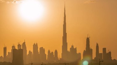 Akşam saatlerinde Dubai şehir merkezinin ufuk çizgisi ile gün batımı. Çölde inşa edilmiş modern gökdelenlerin güzel gökdelenleri. Havaalanı yakınındaki binadan hava görüntüsü