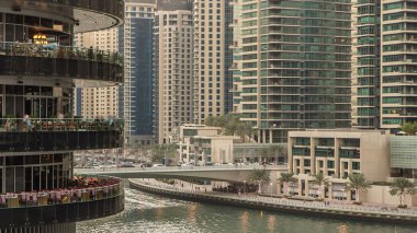 Dubai Marina rıhtımı kuleleri ve Dubai 'deki alışveriş merkezinin balkonundan restoranlara yakın köprüsü olan Birleşik Arap Emirlikleri hava geçiş zamanı..