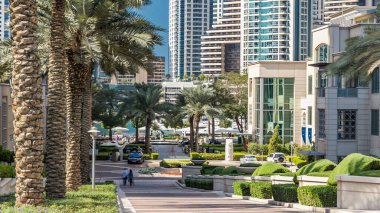 Yat limanında çeşme ve palmiyeler gün içinde modern kulelerle yürüyor. Dubai, BAE