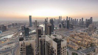 Günbegün modern şehrin hava manzarası trafik ve aydınlık gökdelenler ile geçiş zamanı, günbatımından sonra ofis binaları. İş Körfezi, Dubai, Birleşik Arap Emirlikleri.