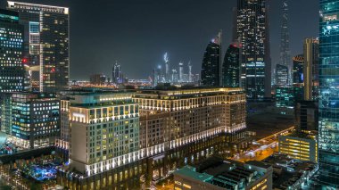 Dubai şehir mimarisi, gece vakti. Şeyh Zayed yolu yakınlarındaki sayısız gökdelenlerin havadan görüntüsü. Işıklı kuleler ve trafik