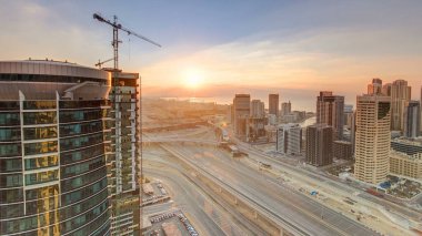 Dubai Marina 'da ve Dubai, BAE' deki JLT gökdelenlerinde günbatımı görüntüsü zamanlaması. Modern kuleler ve Şeyh Zized yolu üzerindeki trafik