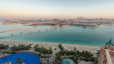 Dubai, BAE 'de gün batımından sonra Jumeirah Palm Island havalimanı. Villalar ve raylı tren yukarıdan görünüyor. Jumeirah Palm Dubai 'de arka planda gökdelenleri olan yapay ve benzersiz bir adadır..