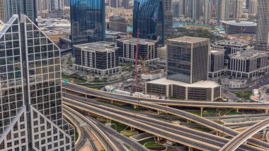 Dubai Şehir Merkezi, gün batımından önce üst hava manzarasını çatıdan çekilmiş gibi gösteriyor. Modern gökdelenler ve yol kavşağı. Dubai, BAE