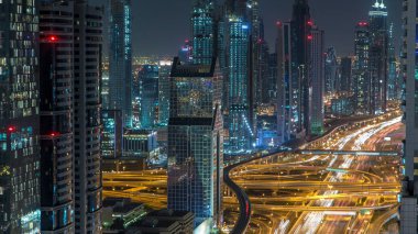 Dubai Şehir Merkezi zaman çizelgesine göre gece üst hava manzarası çatıdan çekilmiş. Modern gökdelenler ve yol kavşağı. Şeyh Zayed yolu. Dubai, BAE