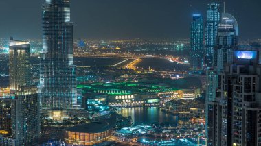 Dubai şehir merkezindeki göl manzaralı, çeşmeli gece saatleri ve çatıdan parkı olan gökdelenler. Skyline şehir merkezi Dubai. Birleşik Arap Emirlikleri