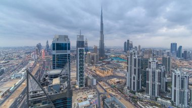 Dubai 'nin panoramik silueti günden geceye geçiş zamanı, Birleşik Arap Emirlikleri. Ünlü gökdelenler kule çatısı manzaralı. Güzel bulutlu gökyüzü. Renkli seyahat ve iş geçmişi
