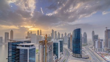 Dubai iş hangarı kuleleri, gün batımında hava zaman tüneli panoramasında. Bazı gökdelenlerin çatı manzarası ve inşaat halindeki yeni kuleler.