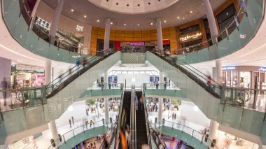 Dubai Mall alışveriş merkezine timelapse üst içinde yürüyen merdiven görüntüleyin. İnsanlar üzerinde birkaç düzeyde. Dubai Mall alışveriş merkezinin toplam alan tarafından dünyanın en büyük alışveriş merkezi olan.