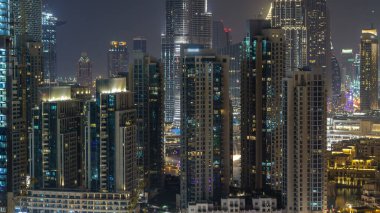Işıklı modern mimarisi içinde Downtown, Dubai, Birleşik Arap Emirlikleri ile gece hava cityscape timelapse. Çatı görünümünden ışıklı finans bölgesi
