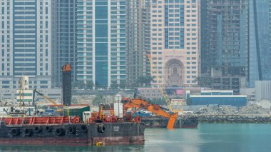 Tarak ve sabah timelapse Palm Jumeirah Adası'Dubai City modern gökdelenler. Dubai, Birleşik Arap Emirlikleri. Dubai Yat Limanı yakınındaki İnşaat