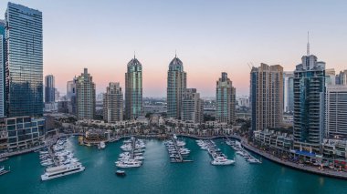 Dubai Marina gökdelenleri hava gününden geceye geçiş zamanı panorama, lüks yatları ve marina gezinti güvertesi olan liman, Dubai, Birleşik Arap Emirlikleri. Aydınlatılmış kuleler ve yol trafiği