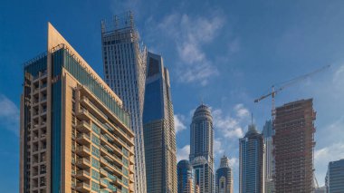 Modern gökdelenler ile Yatlar Dubai, Birleşik Arap Emirlikleri Dubai Marina gündoğumu ışıklar timelapse parlayan bir bakış. Camına yansıyan ışık ışınları.