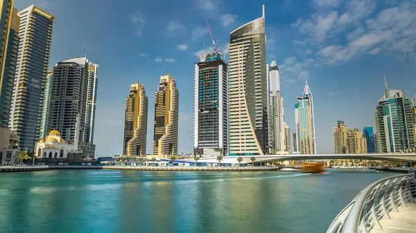 Dubai Marina modern kuleleri yüzen yatları ve gezinti güvertesinden botları olan Birleşik Arap Emirlikleri. Gökdelenlerin en yükseği. Mavi bulutlu gökyüzü
