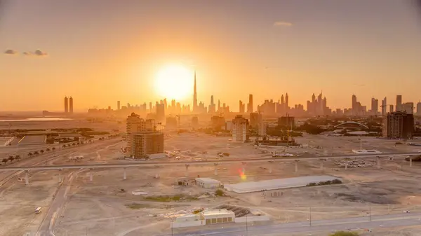 Sunset with skyline of Downtown Dubai in the evening timelapse. Beautiful skyline of modern skyscrapers of city built in the desert. Aerial view from building near airport